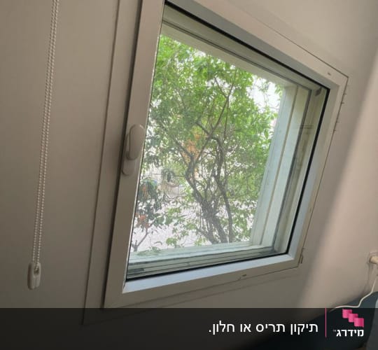 חלון עם תריסים פתוחים וחוט משיכה